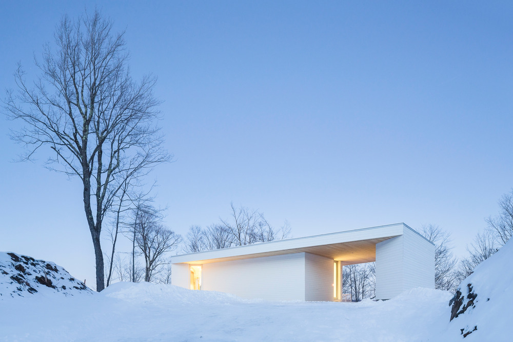 خانه مدرن و سفید با چشم انداز زمستانی در کبک کانادا